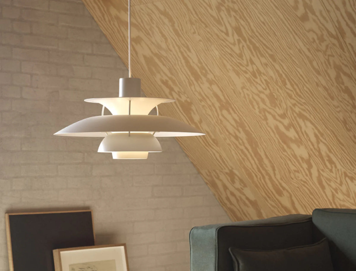 Louis Poulsen PH5 pendant in white under a sloped plywood ceiling